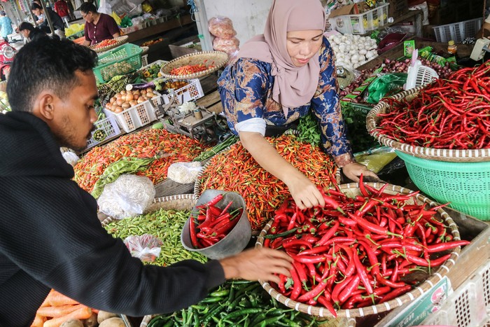 Pedagang melayani pembeli cabai di Pasar Besar Palangka Raya, Kalimantan Tengah, Jumat (10/1/2025). Menurut pedagang, harga cabai di pasar tersebut mengalami kenaikan seperti cabai tanjung dari harga Rp50 ribu menjadi Rp100 ribu per kilogram, cabai rawit dari Rp70 ribu menjadi Rp110 ribu per kilogram dan cabai hijau dari Rp30 ribu menjadi Rp70 ribu per kilogram karena kurangnya pasokan. ANTARA FOTO/Auliya Rahman/nym.