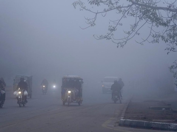 Kabut Tebal Bikin Jarak Pandang Terbatas di Pakistan People sit around a fire to warm themselves as dense fog envelopes the area of Lahore, Pakistan, Friday, Jan. 10, 2025. (AP Photo/K.M. Chaudhry)
