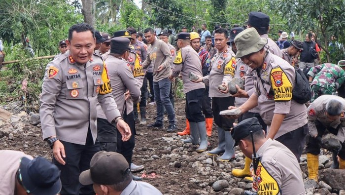 Kapolres Bondowoso AKBP Lintar Mahardhono (kiri) memimpin bakti sosial di lokasi banjir bandang Maesan