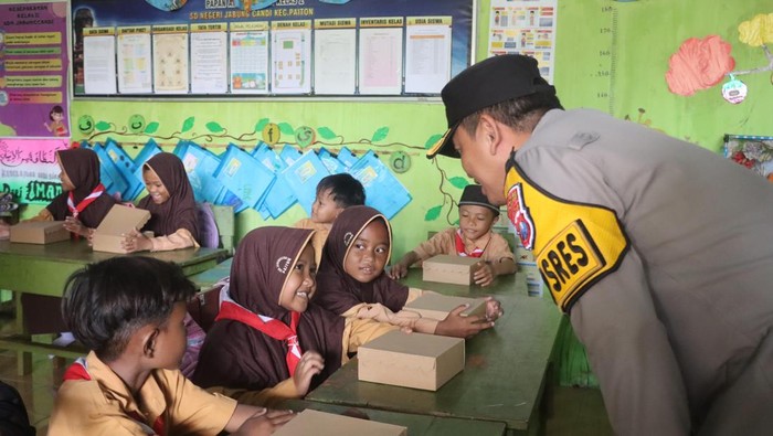 Kapolres Probolinggo AKBP Wisnu Wardana berbincang dengan siswa saat pembagian makan bergizi gratis