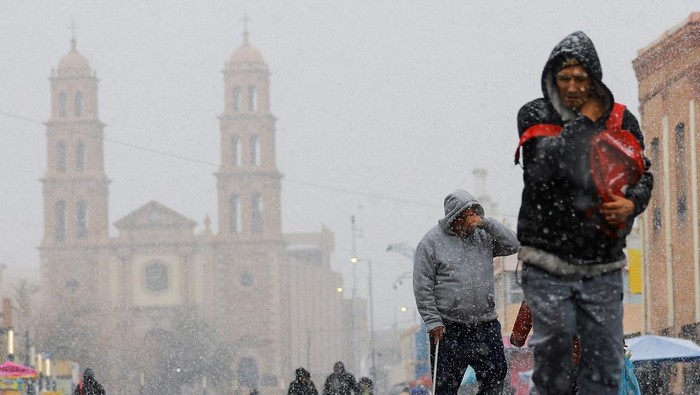 Menikmati Hujan Salju di Meksiko People walk near a bonfire as it snows in Ciudad Juarez, Mexico, January 9, 2025. REUTERS/Jose Luis Gonzalez