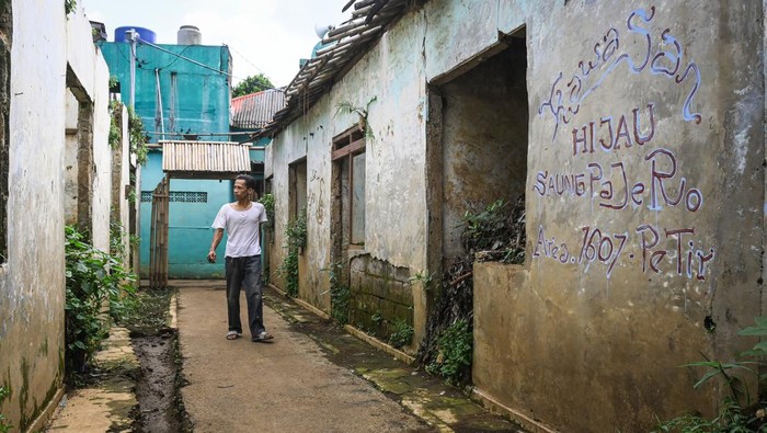 Menyusuri Permukiman Terbengkalai di Bantaran Sungai Ciliwung Seorang warga berjalan di antara bangunan yang terbengkalai di kawasan RW 07 Kelurahan Pejaten Timur, Pasar Minggu, Jakarta, Jumat (10/1/2025). Menurut warga, puluhan rumah di permukiman tersebut telah ditinggalkan pemiliknya karena rusak terendam banjir serta masuk dalam rencana kawasan normalisasi Sungai Ciliwung. ANTARA FOTO/Sulthony Hasanuddin/nz