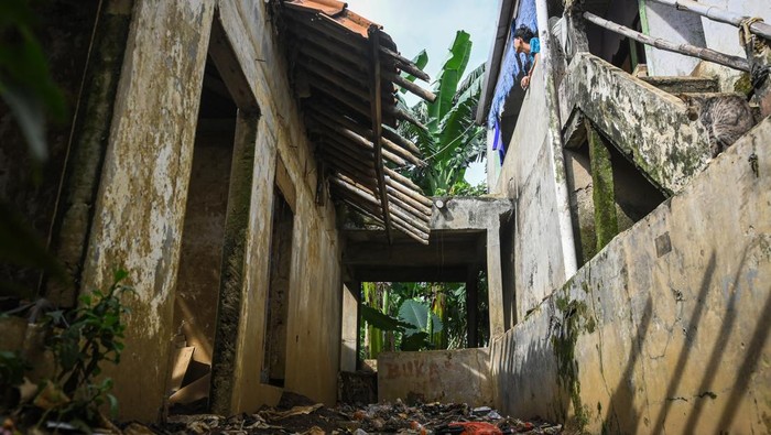 Seorang warga berjalan di antara bangunan yang terbengkalai di kawasan RW 07 Kelurahan Pejaten Timur, Pasar Minggu, Jakarta, Jumat (10/1/2025). Menurut warga, puluhan rumah di permukiman tersebut telah ditinggalkan pemiliknya karena rusak terendam banjir serta masuk dalam rencana kawasan normalisasi Sungai Ciliwung. ANTARA FOTO/Sulthony Hasanuddin/nz