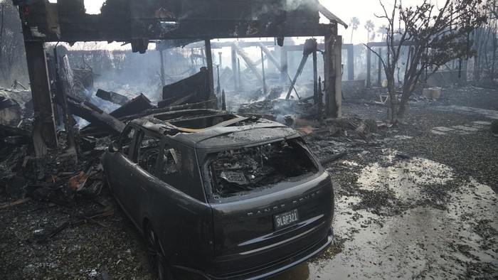Mobil-mobil Hangus Jadi Saksi Bisu Ganasnya Kebakaran Hutan di California The Palisades Fire ravages a neighborhood amid high winds in the Pacific Palisades neighborhood of Los Angeles, Thursday, Jan. 9, 2025. (AP Photo/Damian Dovarganes)