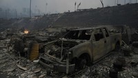 Kebakaran tidak hanya membakar hutan, tapi juga rumah dan mobil-mobil warga. AP/Damian Dovarganes