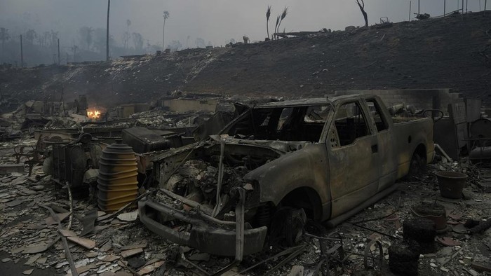 Mobil-mobil Hangus Jadi Saksi Bisu Ganasnya Kebakaran Hutan di California A vehicle and other structures are burned as the Palisades Fire ravages a neighborhood amid high winds in the Pacific Palisades neighborhood of Los Angeles, Wednesday, Jan. 8, 2025. (AP Photo/Damian Dovarganes)