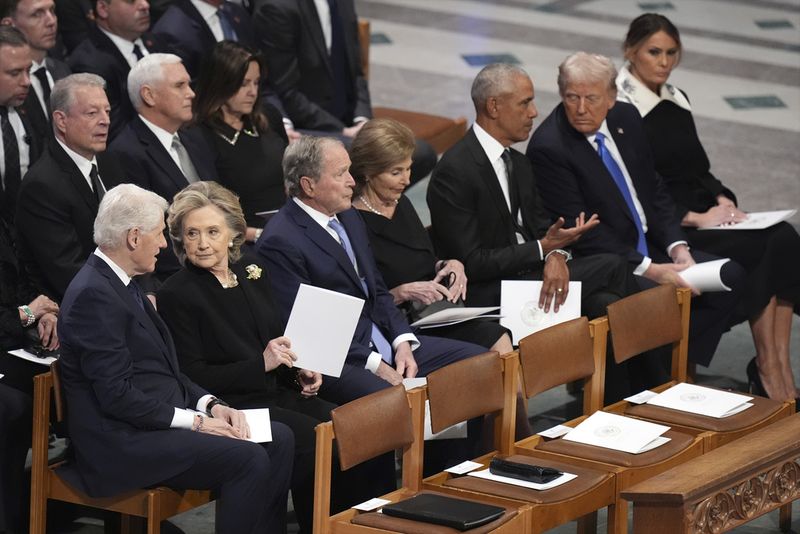 Former President Barack Obama talks with President-elect Donald Trump as Melania Trump reads the funeral program before the state funeral for former President Jimmy Carter at Washington National Cathedral in Washington, Thursday, Jan. 9, 2025. (AP Photo/Jacquelyn Martin)