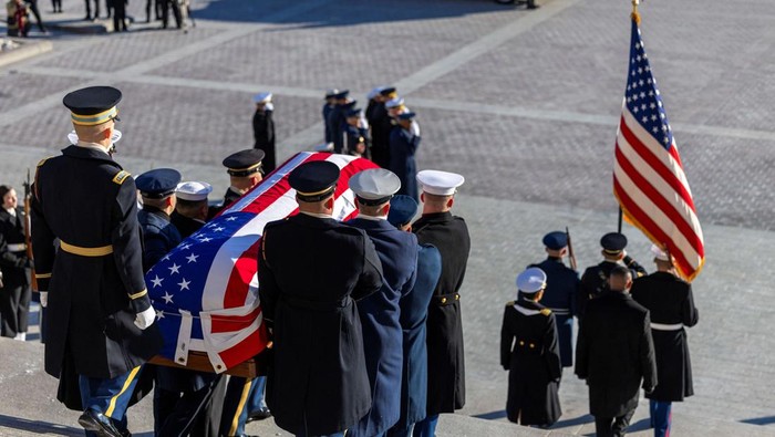 The flag-draped casket of former U.S. President Jimmy Carter is carried by a joint services military honor guard down the steps of the U.S. Capitol in Washington, U.S., January 9, 2025. REUTERS/Jeenah Moon/Pool      TPX IMAGES OF THE DAY