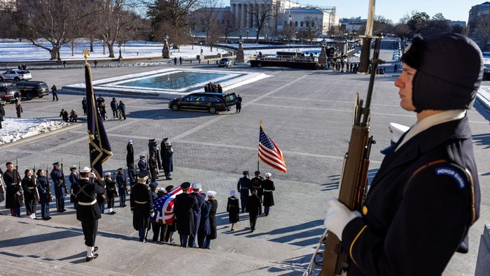 Momen Jenazah Jimmy Carter Dibawa Keluar Gedung Capitol The flag-draped casket of former U.S. President Jimmy Carter is carried by a joint services military honor guard down the steps of the U.S. Capitol in Washington, U.S., January 9, 2025. REUTERS/Jeenah Moon/Pool TPX IMAGES OF THE DAY