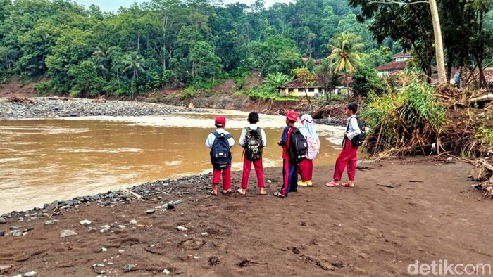 Para siswa di Sukabumi menembus aliran sungai untuk pergi ke sekolah.