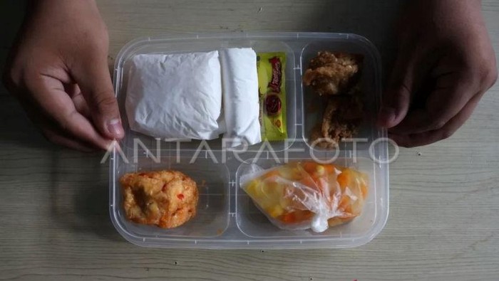 Siswa memperlihatkan menu makanan yang dibagikan saat peluncuran makan bergizi gratis (MBG) di SMP Negeri 1 Makassar, Sulawesi Selatan.
