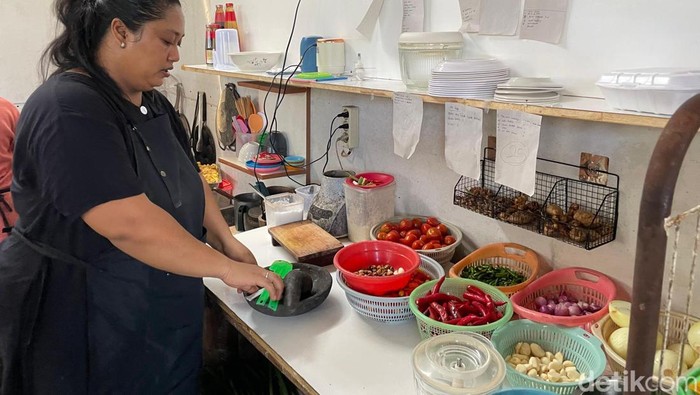 Desi sedang menyiapkan menu makan untuk para pelanggannya