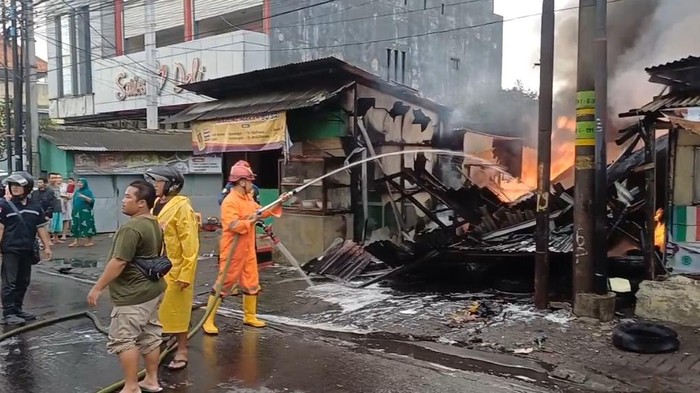 Pemadam kebakaran saat berusaha memadamkan api yang menghanguskan sebuah kios di Jalan Diponegoro, Ungaran, Semarang, Sabtu (11/1/2025).