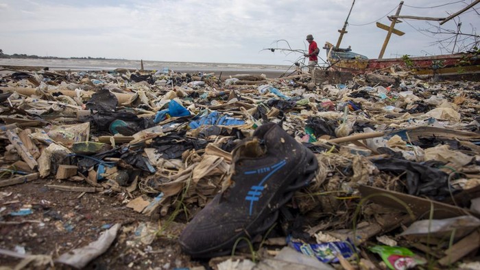 Warga melihat kondisi pantai yang penuh dengan tumpukan sampah di Pantai Dadap, Indramayu, Jawa Barat, Minggu (12/1/2025). Sampah yang sebagian besar dari limbah rumah tangga dan plastik tersebut terseret arus dan menumpuk di pantai sehingga mengganggu aktivitas nelayan. ANTARA FOTO/Dedhez Anggara/nym.