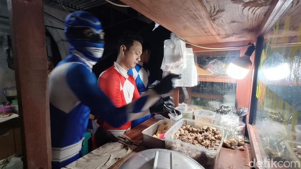 Para karyawan mengenakan kostum Power Rangers saat melayani pembeli di Bakso Jimpeng, Jalan Jenderal Soedirman, Purwokerto, Banyumas, Sabtu (11/1/2025) malam.