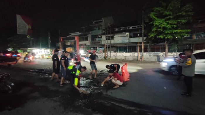 Relawan dan Polisi Sidoarjo Bersatu Tambal Jalan Rusak