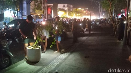 Sejumah anak muda sibuk mencari Koin Jagat di Jalan Raya Kuta, Badung, Bali, Minggu (12/1/2025).