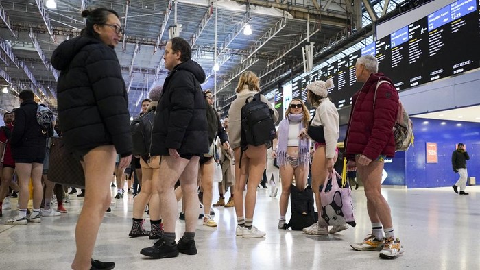 People walk along an underground station's platform as they take part in the annual event 