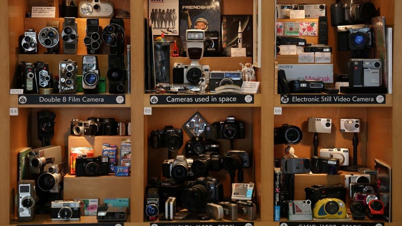 Visitors view items inside Extinct Media Museum, a private museum showcasing a collection of defunct gadgets including old cameras, cassette tapes and cell phone, in Tokyo, Japan January 11, 2025.  REUTERS/Irene Wang