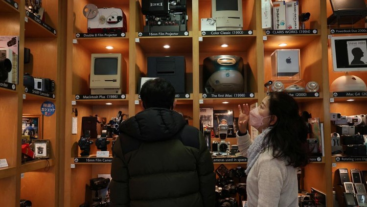 Visitors view items inside Extinct Media Museum, a private museum showcasing a collection of defunct gadgets including old cameras, cassette tapes and cell phone, in Tokyo, Japan January 11, 2025.  REUTERS/Irene Wang