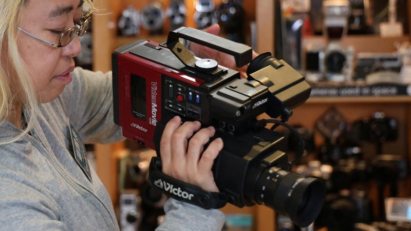 Visitors view items inside Extinct Media Museum, a private museum showcasing a collection of defunct gadgets including old cameras, cassette tapes and cell phone, in Tokyo, Japan January 11, 2025.  REUTERS/Irene Wang