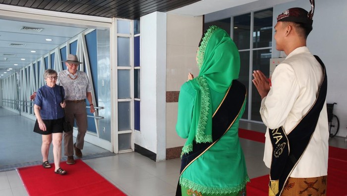 Petugas menyambut dua wisatawan saat turun dari kapal pesiar MS Seven Seas Voyager di Gapura Surya Nusantara, Pelabuhan Tanjung Perak, Surabaya, Jawa Timur, Senin (13/1/2025). Kapal pesiar berbendera Bahama itu merupakan kapal pesiar yang pertama berkunjung di Surabaya pada tahun 2025 dengan membawa 648 wisatawan mancanegara untuk mengunjungi sejumlah tempat wisata di Surabaya dan Mojokerto. ANTARA FOTO/Didik Suhartono/YU