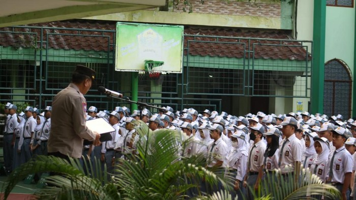 Personel Ditbinmas Polda Metro Jaya menjadi inspektur upacara bendera di SMA Jakarta.