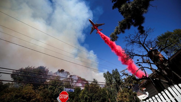 A plane makes a drop as smoke billows from the Palisades Fire at the Mandeville Canyon, in Los Angeles, California, U.S., January 11, 2025. REUTERS/Carlos Barria TPX IMAGES OF THE DAY