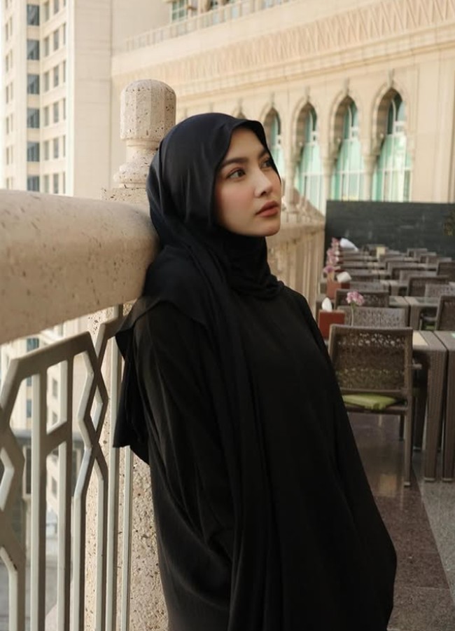 Penampilan Mahalini terlihat pangling saat umrah pertamanya ketika tengah hamil besar tujuh bulan. Ia terlihat memesona saat mengenakan hijab pashmina mleyot dan abaya hitam. Istri Rizky Febian ini membentuk hijab menutupi leher dan menyampirkan satu sisi ke belakang ketika berada di Mekkah. Foto: Dok. Instagram @rizkyfbian.
