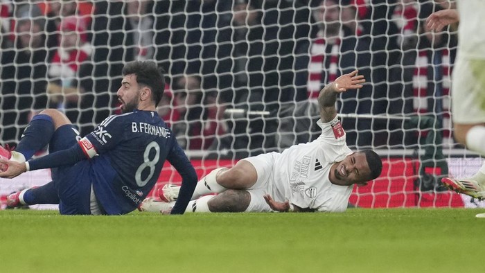 Arsenals Gabriel Jesus, bottom right, reacts after injuring during the English FA Cup soccer match between Arsenal and Manchester United at the Emirates stadium in London, Sunday, Jan. 12, 2025. (AP Photo/Kin Cheung)
