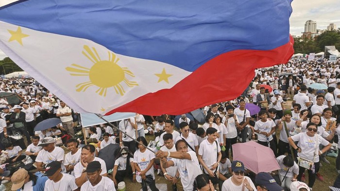 Jutaan Warga Filipina Turun ke Jalan, Tolak Wapres Sara Duterte Dimakzulkan A man waves a flag as he participates in the National Rally for Peace organized by a religious group in support of Philippine Vice President Sara Duterte, who is facing impeachment complaints, in Manila, Monday, Jan. 13, 2025. (AP Photo/Noel Celis)
