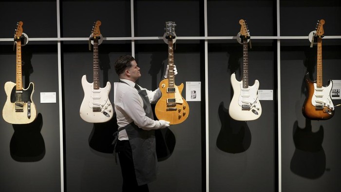 An art handler displays a Gibson, Kalamazoo, Michigan, circa 1959 and later A Solid-Body Electric Guitar, Les Paul, known as 'The Yardburst' at the Jeff Beck The Guitar Collection in London, England, Tuesday, Jan. 14, 2025, ahead of the pre-sale exhibition at Christies auction rooms in London. (AP Photo/Kirsty Wigglesworth)