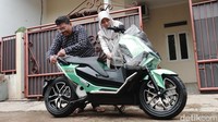 Pemenang yang merupakan pasangan suami istri dengan bahagia membuka plastik kendaraan. Mereka mengaku tak menyangka terpilih sebagai pemenang. Foto: Septian Farhan Nurhuda / detikOto