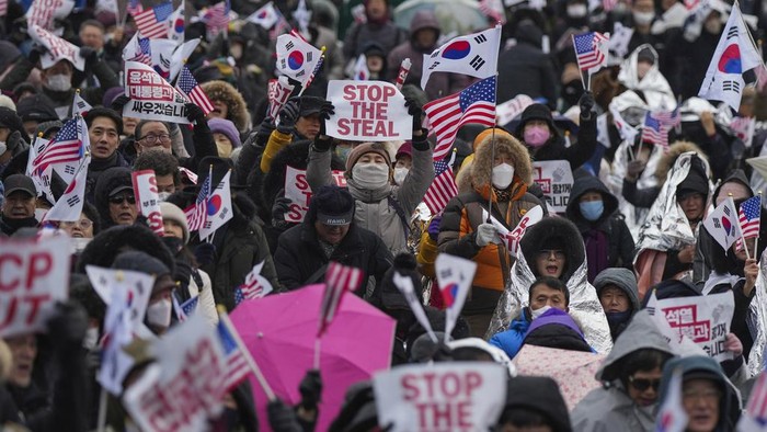 Pendukung Presiden Yoon Suk Yeol Berunjuk Rasa di Tengah Cuaca Membeku Supporters of impeached South Korean President Yoon Suk Yeol shout slogans during a rally to oppose his impeachment near the presidential residence in Seoul, South Korea, Monday, Jan. 13, 2025. (AP Photo/Lee Jin-man)