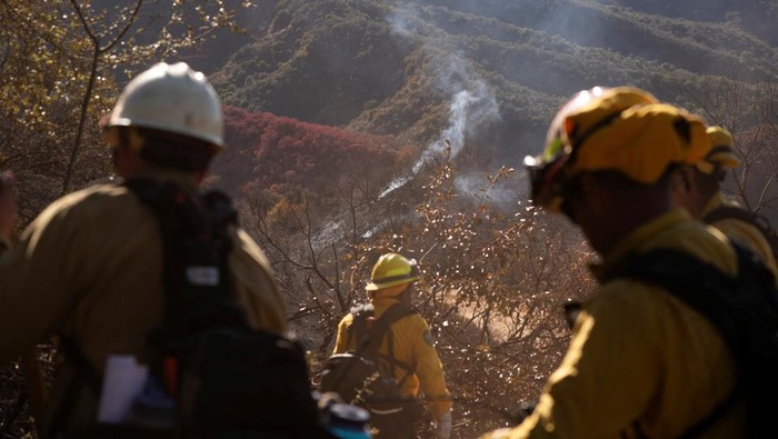 Potret Petugas Damkar Meksiko Bantu Tangani Kebakaran Hutan Los Angeles Firefighters from Mexico hike to their destination to cut a containment line in the Tarzana area during the Palisades Fire in Los Angeles, California, U.S. January 13, 2025. REUTERS/David Ryder