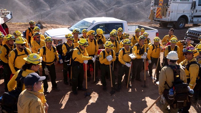 Firefighters from Mexico hike to their destination to cut a containment line in the Tarzana area during the Palisades Fire in Los Angeles, California, U.S. January 13, 2025. REUTERS/David Ryder