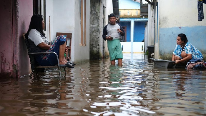 Seorang warga membersihkan karpet di jalan yang terendam banjir rob di Jeruju 3 Dalam, Pontianak, Kalimantan Barat, Selasa (14/1/2025). BMKG Kalbar memprakirakan puncak air pasang di Kota Pontianak dan sekitarnya akan berlangsung hingga 18 Januari 2025. ANTARA FOTO/Jessica Wuysang/rwa.
