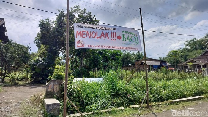 Spanduk penolakan proyek Baqi Memorial Parkdi Desa Pandanmulyo, Tajinan, Malang