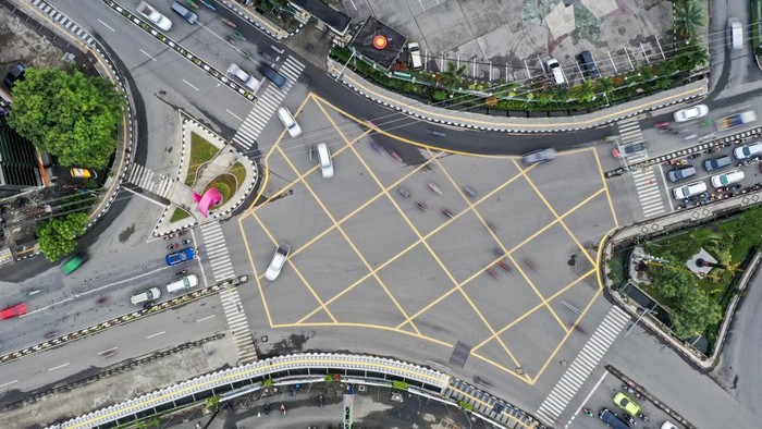 Foto udara sejumlah pengendara kendaraan bermotor melintasi Yellow Box Junction atau kotak marka kuning di persimpangan jalan Lembuswana, Samarinda, Kalimantan Timur, Senin (13/1/2025). Dinas Perhubungan (Dishub) Samarinda menerapkan kotak marka kuning di dua titik strategis di Samarinda yang berfungsi untuk mengatasi kemacetan di titik-titik rawan padat kendaraan bermotor. ANTARA FOTO/M Risyal Hidayat/nz