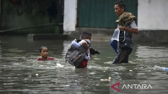 Warga melintasi banjir rob di Muara Angke, Jakarta, Senin (13/1/2025). BPBD DKI Jakarta mengimbau warga pesisir utara Jakarta untuk waspada terhadap potensi banjir rob hingga 17 Januari 2025 akibat pasang maksimum air laut yang bertepatan dengan fase Bulan Purnama. (ANTARA FOTO/Muhammad Ramdan/Spt/pri)