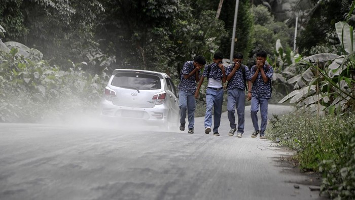 Pengendara sepeda motor melintas di jalan umum yang tertutup abu vulkanik dampak erupsi Gunung Ibu di Desa Tobaro, Kabupaten Halmahera Barat, Maluku Utara,Rabu (15/1/2025). Erupsi Gunung Ibu pada Rabu (15/1) pukul 07.11 WIT dengan semburan abu vulkanik setinggi 4.000 dari atas puncak menyebabkan sejumlah desa di Kecamatan Ibu Utara mengalami hujan abu, sementara gunung tersebut masih menunjukkan peningkatan aktivitas dan PVMBG menaikan status Gunung Ibu dari Siaga Level III menjadi Awas Level IV.