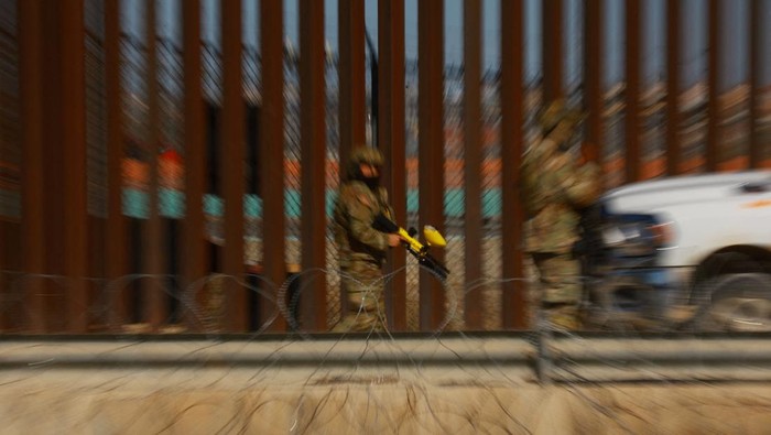 A Texas National Guard member stands guard near a razor-wire fence to inhibit migrants' crossing into the United States, as seen from Ciudad Juarez, Mexico,  January  14, 2025. REUTERS/Jose Luis Gonzalez