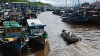 Warga menaiki perahu motor saat melewati barisan kapal penangkap ikan di Pelabuhan Sungai Kakap di Kabupaten Kubu Raya, Kalimantan Barat, Rabu (15/1/2025).  