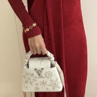 Pada pergelangan tangannya, Lisa BLACKPINK menambahkan gelang mewah dari brand perhiasan Paris, Van Cleef & Arpels. Hand bag putih yang dipakainya memiliki detail payet bernuansa Natal. Koleksi tas Louis Vuitton Capucines Mini bernilai £7,600 atau sekitar Rp 151 jutaan. Foto: dok. Instagram @lalalalisa_m