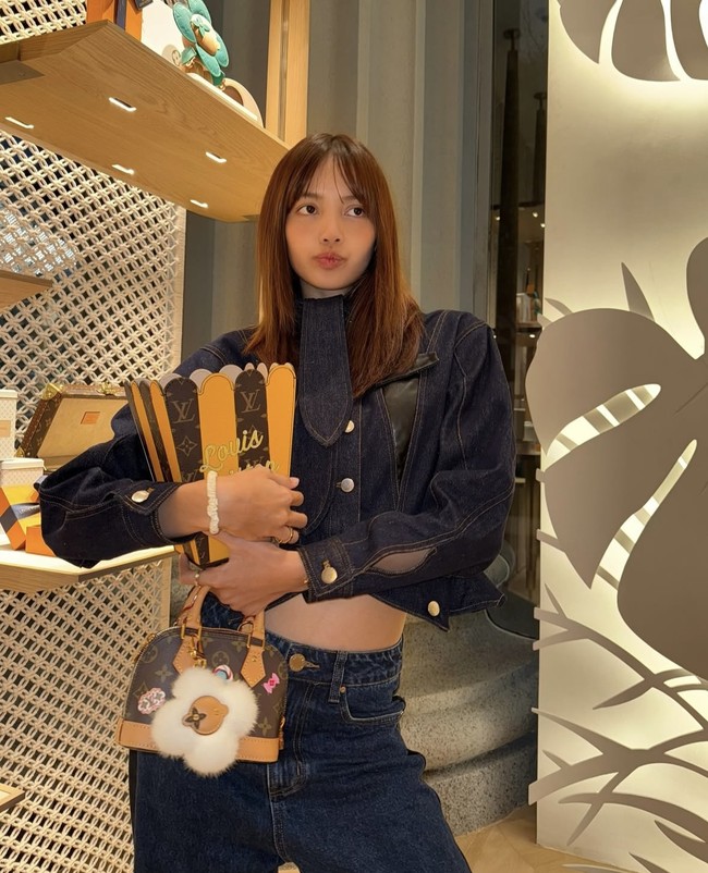 Sebagai global ambassador Louis Vuitton, Lisa BLACKPINK tak pernah absen memakai koleksi tasnya. Saat melakukan visit store di Thailand, dia tampak memegang koleksi tas capsule berbentuk keranjang pop corn dengan warna vibrant kuning dan emblem logo Louis Vuitton seharga Rp 17,5 juta. Foto: dok. Instagram @lalalalisa_m