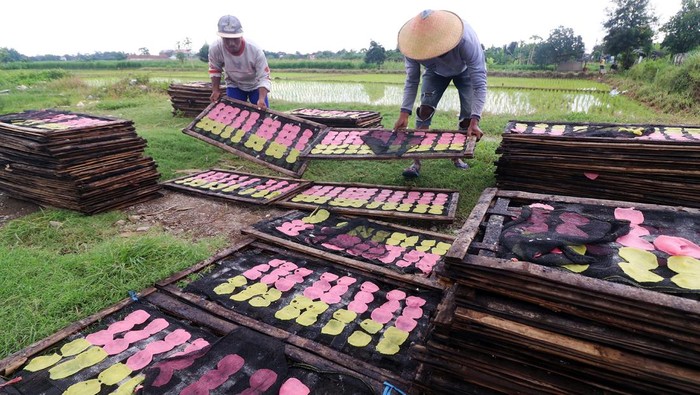 Pekerja menjemur kerupuk upil khas Kediri di sentra industri rumahan kerupuk Desa Bulusari, Kabupaten Kediri, Jawa Timur, Rabu (15/1/2025). Produksi kerupuk upil khas Kediri mengalami penurunan produksi hingga 50 persen dari sebelumnya 4 kuintal menjadi 2 kuintal per hari akibat tingginya intensitas hujan yang mengakibatkan proses pengeringan terganggu. ANTARA FOTO/Prasetia Fauzani/agr