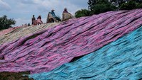 Pekerja menjemur kain pantai di sentra industri rumahan Desa Krajan, Mojolaban, Kabupaten Sukoharjo, Jawa Tengah, Selasa (14/1/2025).   