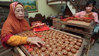 Pekerja melabel kue keranjang sebelum dikemas di rumah industri kue keranjang di Surabaya, Jawa Timur, Rabu (15/1/2025).   