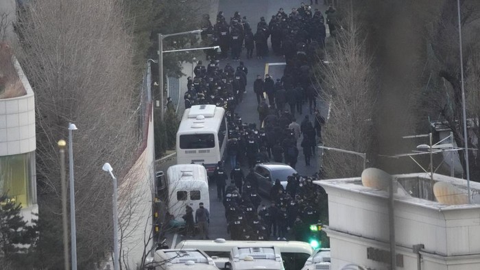 Investigators from the state anti-corruption agency and police officers make their way to the residence of impeached President Yoon Suk Yeol to execute a warrant to detain Yoon in Seoul, South Korea, Wednesday, Jan. 15, 2025. (AP Photo/Ahn Young-joon)