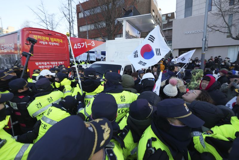 Police officers walk to the gate of the presidential residence in Seoul, South Korea, Wednesday, Jan. 15, 2025. (AP Photo/Lee Jin-man)